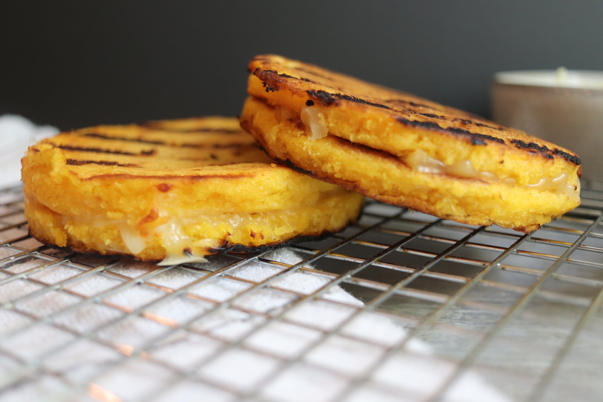 Arepa de chocolo served on an aluminum platter with a cup of cheese on the side. Yummy colombian cheese arepa for your everyday snack.